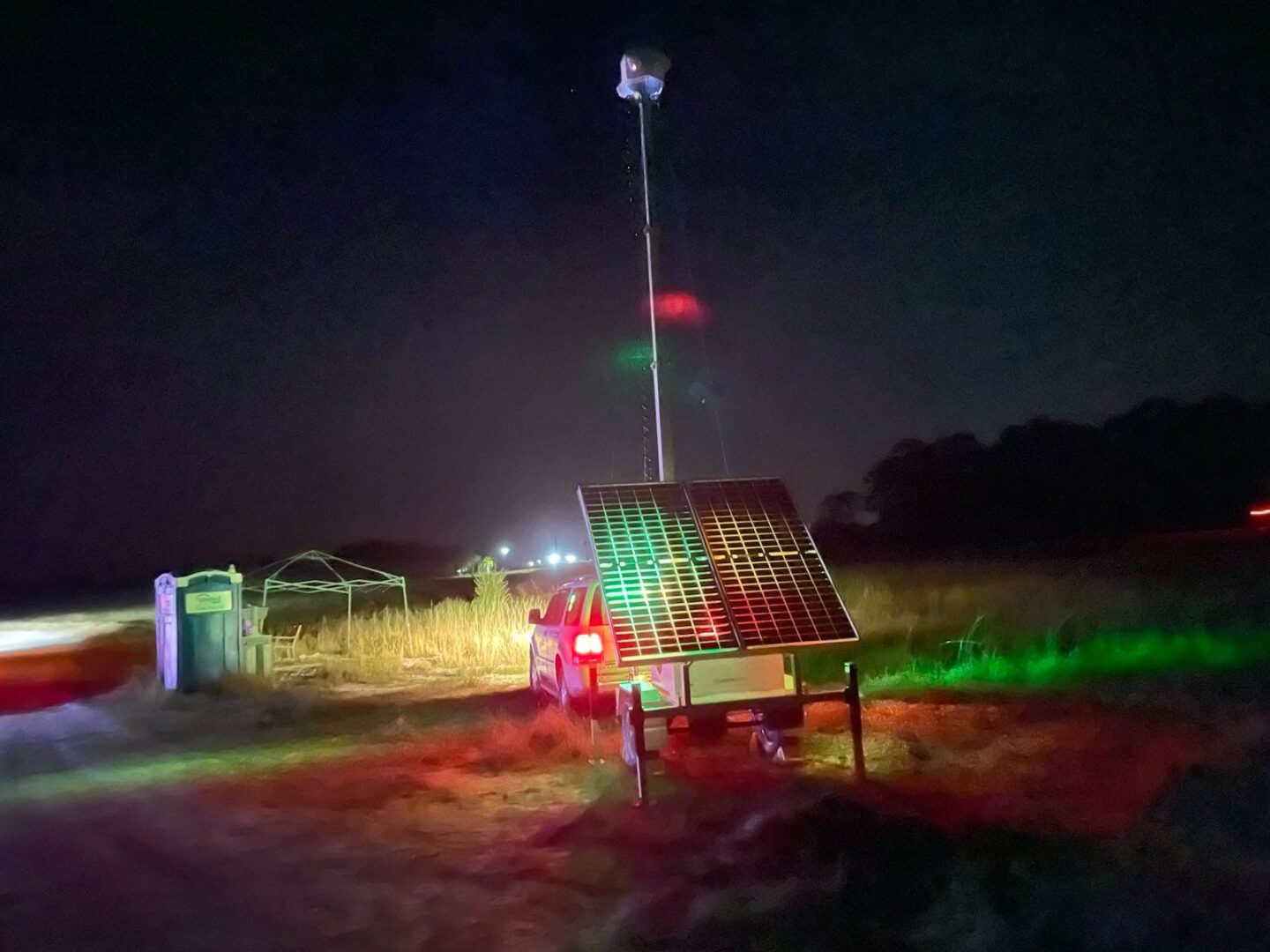 A solar panel sitting in the middle of a field.