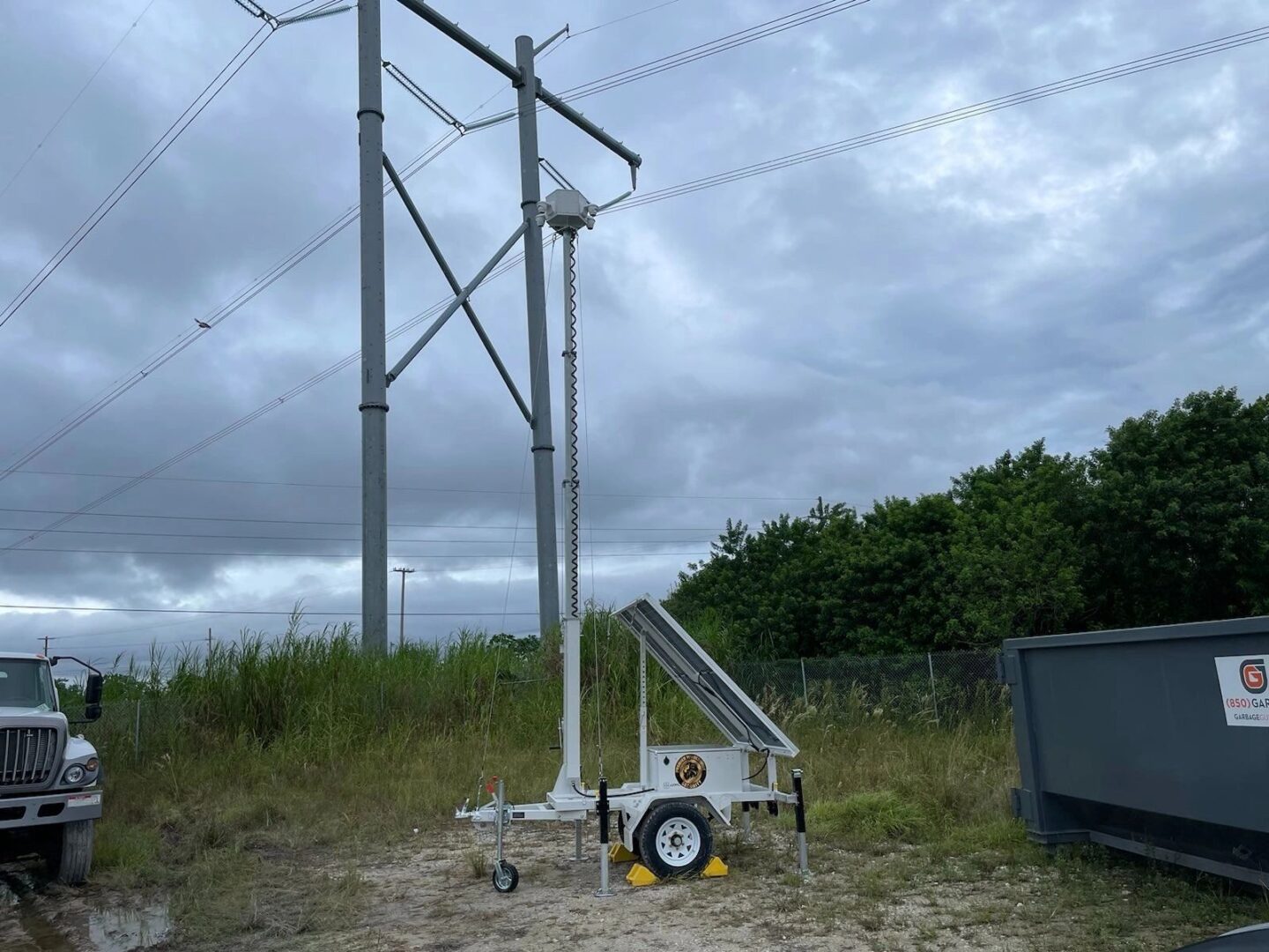 A utility trailer with a large pole and a crane.